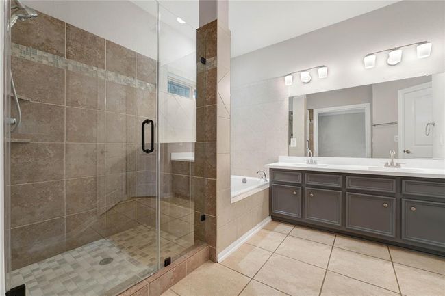 beautiful primary bath with quartz countertops soaking tub and extended standup shower. | Image 33