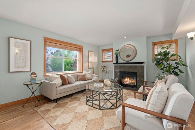 You're going to love how spacious the living room is. Hardwood floors, gas fireplace, big window with sill for your plants. | Image 6