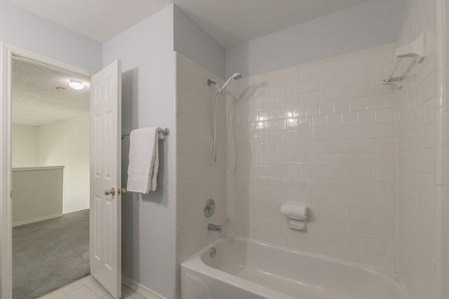 Full bathroom with baseboards, washtub / shower combination, and a textured ceiling | Image 22
