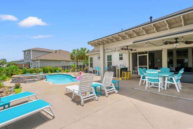 View of pool featuring a patio, a ceiling fan, a grill, and a pool with connected hot tub | Image 28