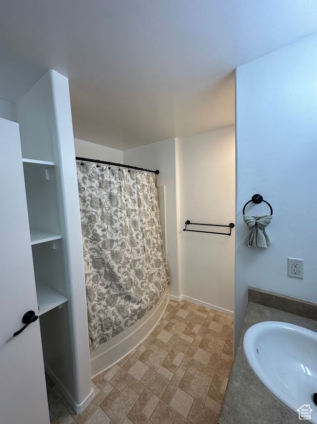 Full bathroom featuring baseboards, curtained shower, and a sink | Image 13