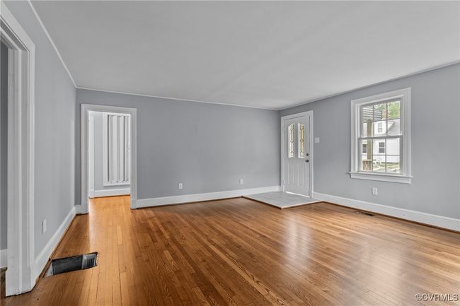 Unfurnished living room featuring visible vents, hardwood / wood-style flooring, and baseboards | Image 6