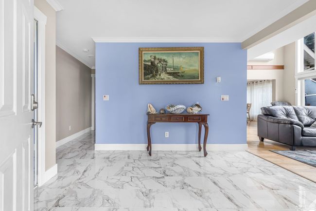 Entryway with ornamental molding, baseboards, marble finish floors, and a wall mounted air conditioner | Image 7