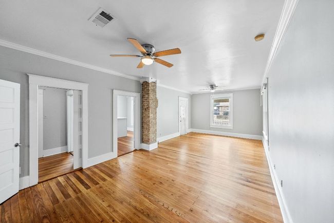 Unfurnished living room featuring a ceiling fan, ornamental molding, baseboards, and light wood finished floors | Image 5
