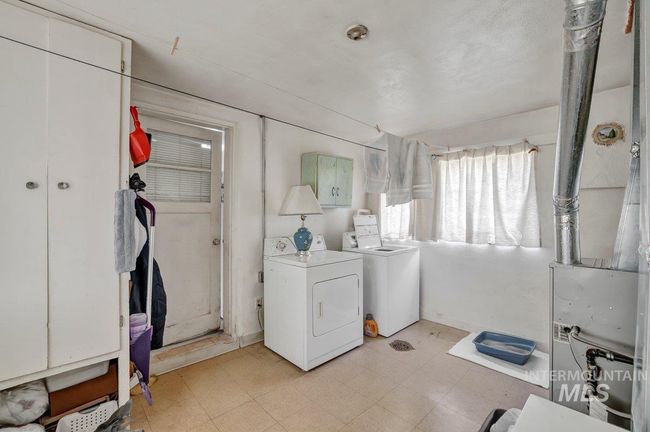 Laundry room with washing machine and clothes dryer, light floors, and cabinet space | Image 16