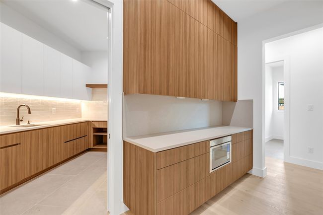 Kitchen with modern cabinets, backsplash, and light countertops | Image 18