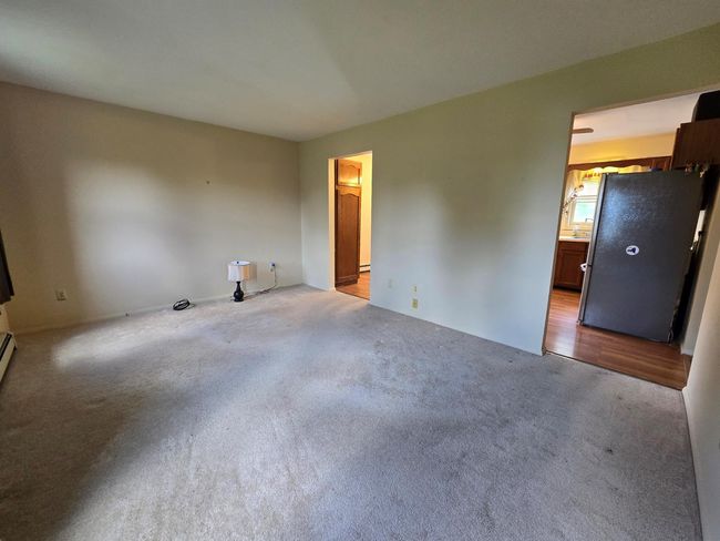 Carpeted empty room featuring baseboard heating | Image 14