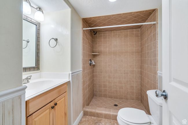 Bathroom featuring a tile shower, toilet, and vanity | Image 25