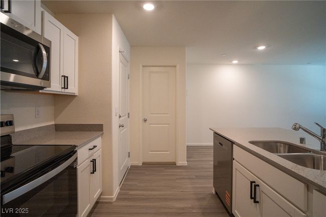 Kitchen with appliances with stainless steel finishes, wood finished floors, white cabinets, and recessed lighting | Image 5