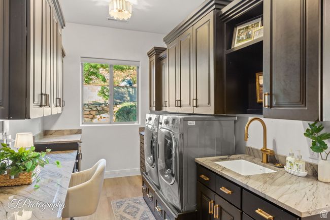 Laundry area with cabinet space, washing machine and dryer, baseboards, and light wood-style floors | Image 68