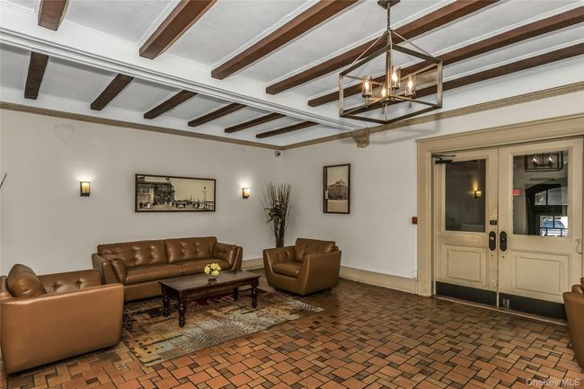 Living area featuring a chandelier, french doors, and beam ceiling | Image 14