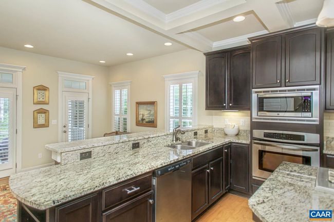 The kitchen includes granite counters, stainless steel appliances, and a wall oven. | Image 11