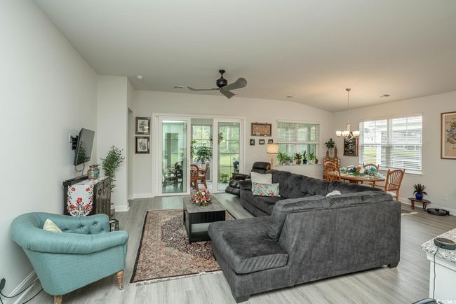 Living area with a chandelier, wood finished floors, and baseboards | Image 22