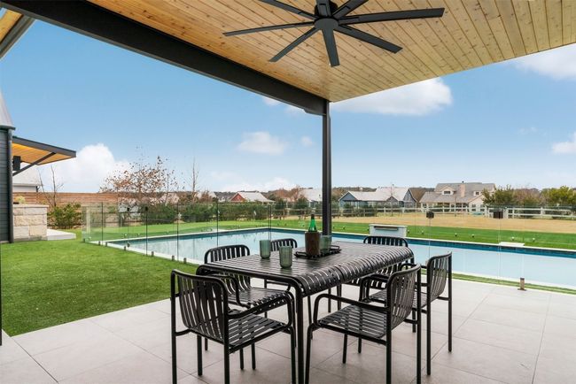 Gather around the dining table on the patio, where the crackling outdoor fireplace adds a touch of magic, making evenings spent with family and friends feel extra special | Image 31