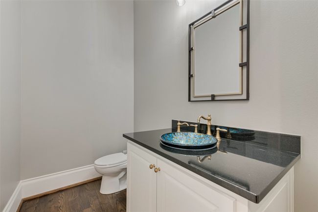 Half bathroom with toilet, vanity, wood finished floors, and baseboards | Image 17