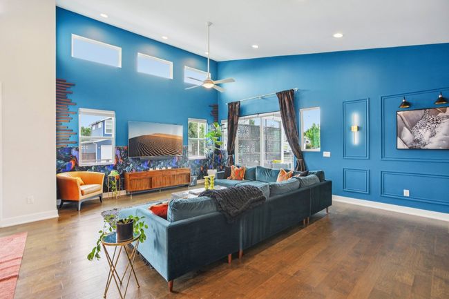 Living room with hardwood / wood-style flooring, recessed lighting, ceiling fan, and a high ceiling | Image 5