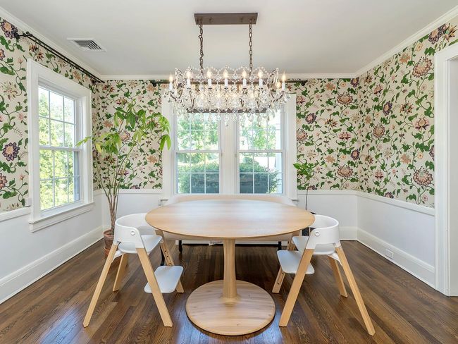 Dining room with wallpapered walls, ornamental molding, a chandelier, wainscoting, and wood finished floors | Image 12