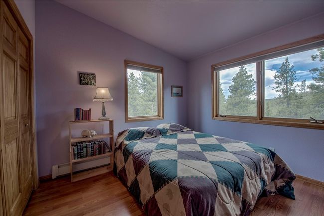Bedroom with a baseboard radiator, lofted ceiling, and wood finished floors | Image 27