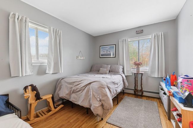 Bedroom with wood finished floors, and multiple windows | Image 18