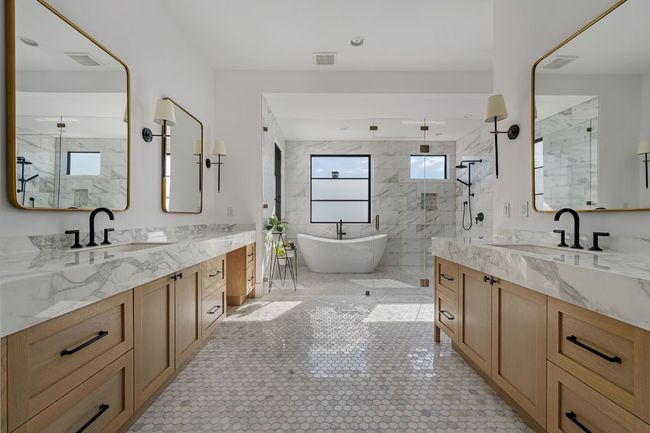 Bathroom featuring a stall shower, two vanities, and a sink | Image 17
