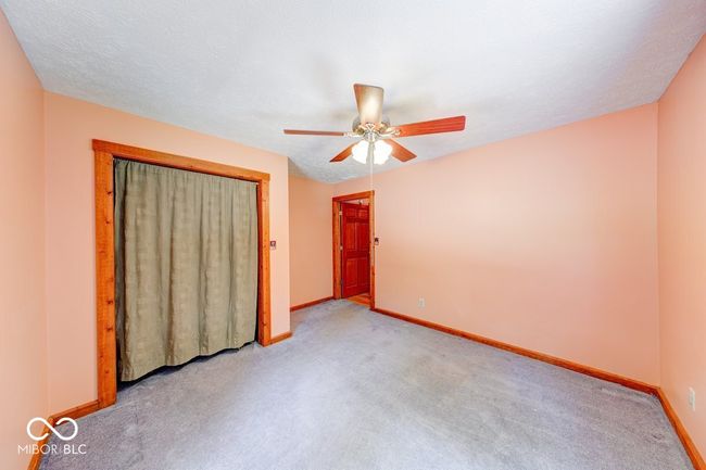 unfurnished bedroom with carpet floors, a closet, and ceiling fan | Image 40