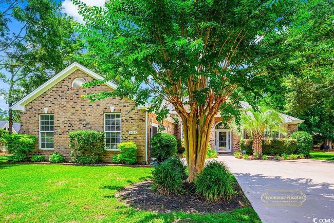 Obstructed view of property featuring brick siding, a front yard, and concrete driveway | Image 6