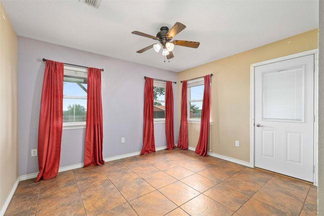 Unfurnished bedroom featuring multiple windows and ceiling fan | Image 15