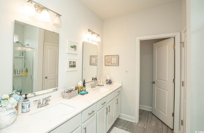 Bathroom with a shower stall, double vanity, and baseboards | Image 28