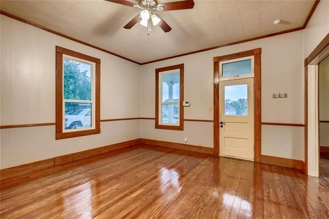 Unfurnished room with hardwood / wood-style floors, crown molding, and ceiling fan | Image 8