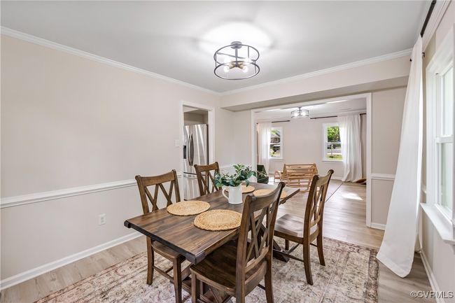 Dining room with an inviting chandelier, light wood-style floors, and crown molding | Image 6