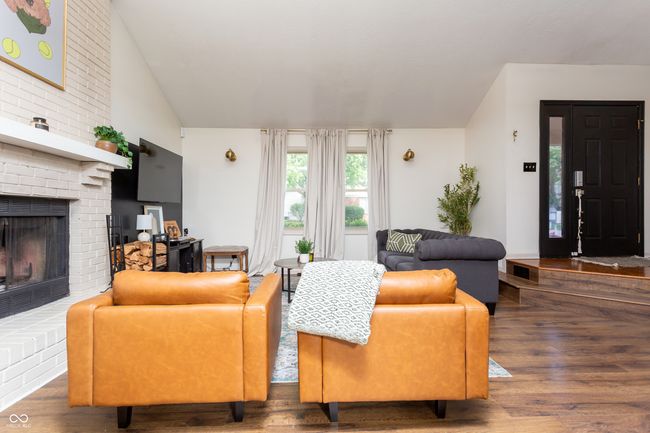 living area with lofted ceiling, wood finished floors, and a fireplace | Image 8