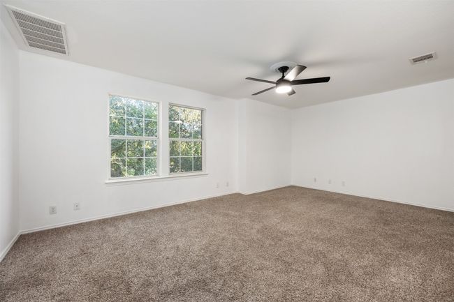 Carpeted empty room featuring visible vents, baseboards, and ceiling fan | Image 31