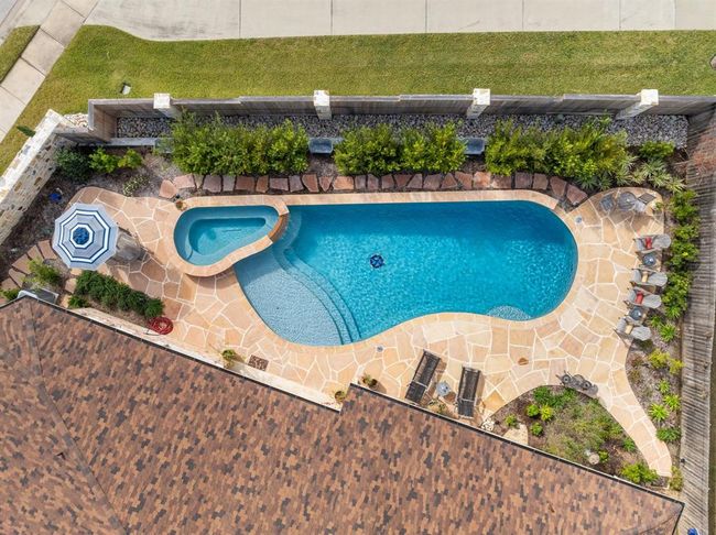 629 sf pool (41' long) plus a separate spa.Including an upgraded 36"x36" Rose Compass Mosaic on the pool floor from Bluewater Pool Mosaics. Upgraded waterline tile: "Hana-Capri" with relief by NPT. Buckskin Natural Flagstone Coping and Deck. Mosquito Misting System.Professional Landscaping | Image 42