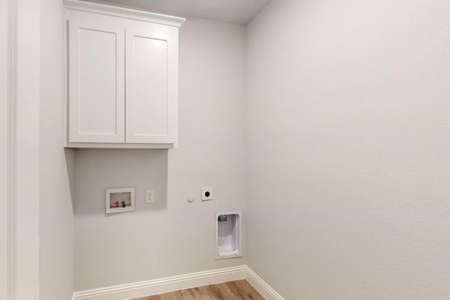 Washroom with electric dryer hookup, hookup for a washing machine, cabinets, light hardwood / wood-style floors, and hookup for a gas dryer | Image 23