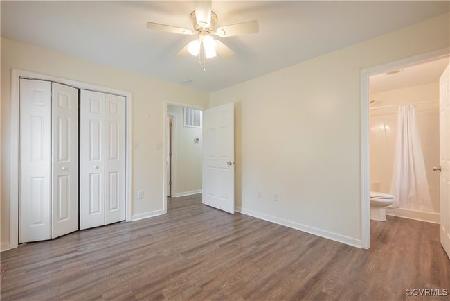 Unfurnished bedroom with a closet, baseboards, visible vents, and wood finished floors | Image 25