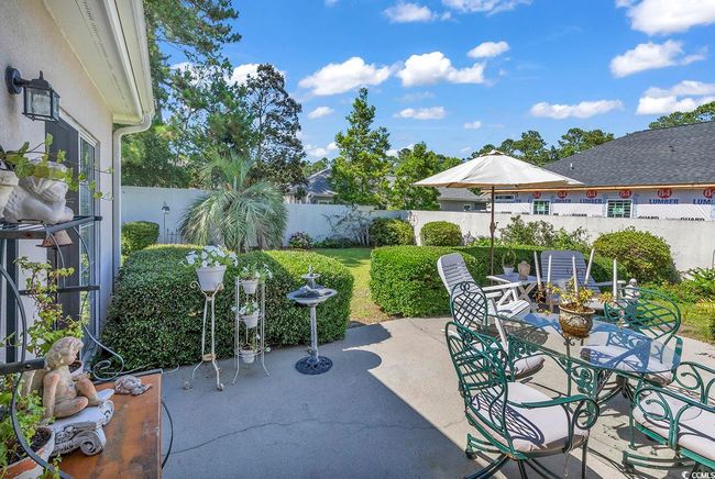 Secluded stone walled backyard with a patio | Image 24