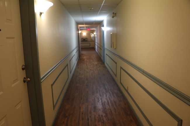 Hall with a drop ceiling and dark wood finished floors | Image 21