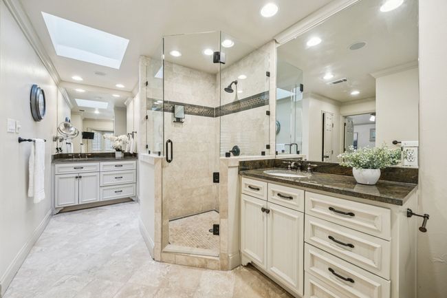 Dual vanities and frameless shower in primary bathroom. | Image 12