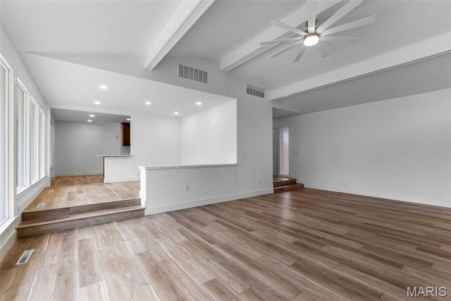 Unfurnished living room featuring vaulted ceiling with beams, ceiling fan, and light hardwood / wood-style flooring | Image 6