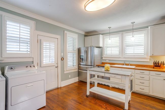 Kitchen with washer / dryer, stainless steel fridge with ice dispenser, healthy amount of natural light, pendant lighting, and ornamental molding | Image 28