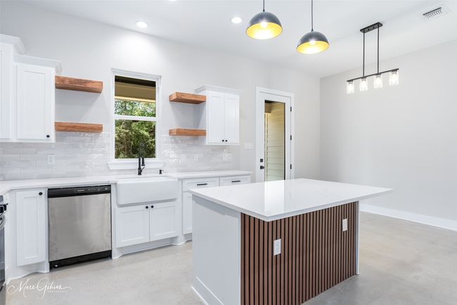 Kitchen with open shelves, tasteful backsplash, dishwasher, and finished concrete flooring | Image 8
