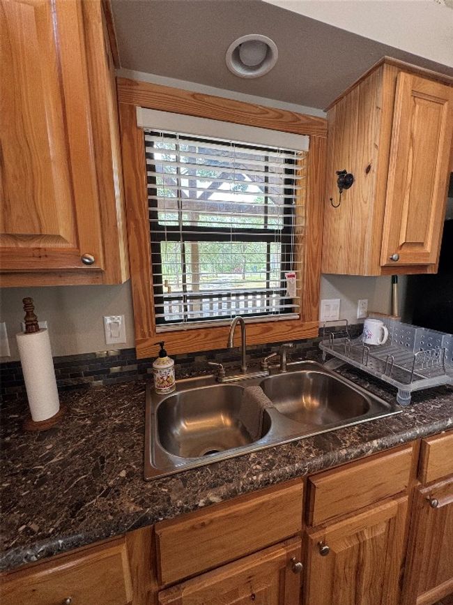 Kitchen with a sink and dark stone counters | Image 31