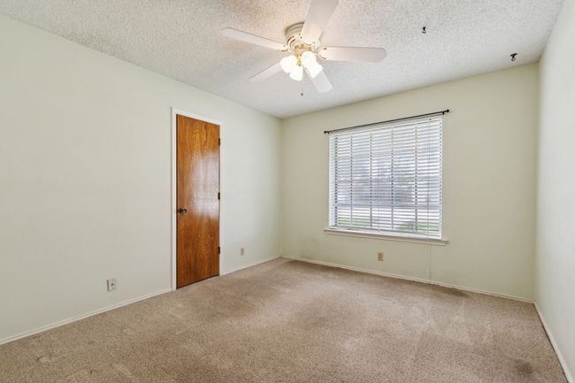 Carpeted spare room with a ceiling fan and a textured ceiling | Image 24