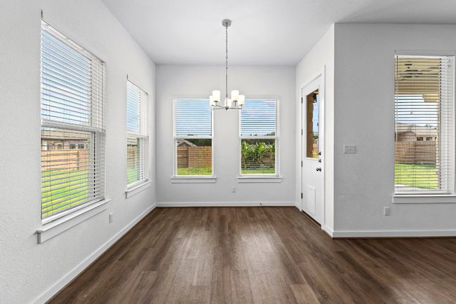 Unfurnished dining area with a chandelier, dark wood-type flooring, and baseboards | Image 21
