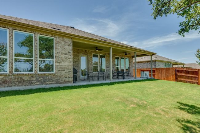 Rear view of house with brick siding, ceiling fan, a patio area, and a shingled roof | Image 27