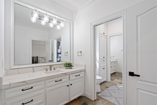 Well-designed Jack and Jill bathroom featuring an extended countertop, upgraded lighting, and white cabinetry, creating a stylish and functional space. | Image 44