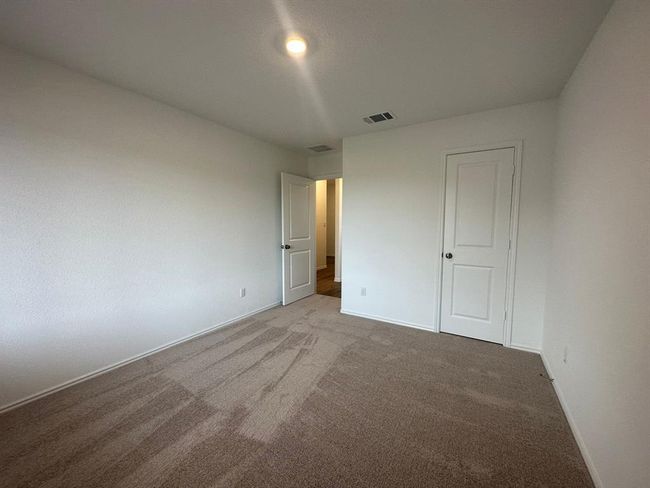 Unfurnished bedroom with light colored carpet and baseboards | Image 8