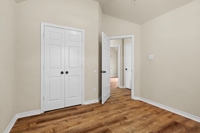 Unfurnished bedroom featuring lofted ceiling, wood finished floors, and a closet | Image 28