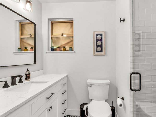 Bathroom featuring vanity, toilet, a shower stall, and baseboards | Image 23