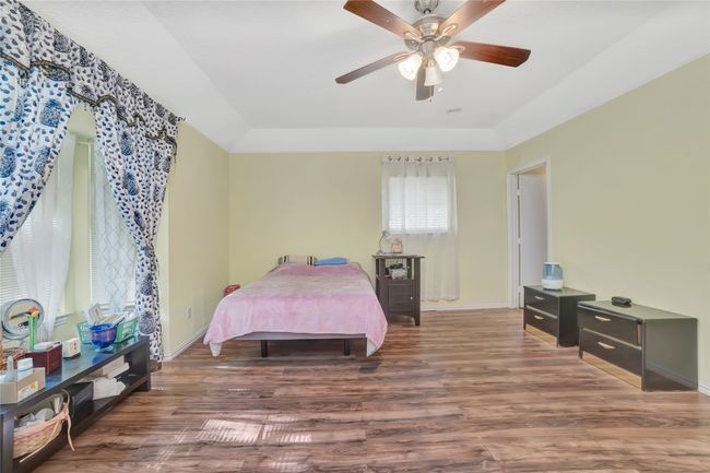 Bedroom with wood finished floors, baseboards, and ceiling fan | Image 17